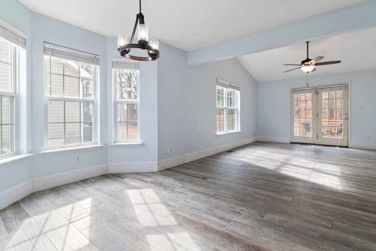 Refinished hardwood flooring in a sunlit Minnesota room with bay windows